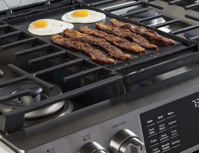 bacon and eggs cooking on the top grate