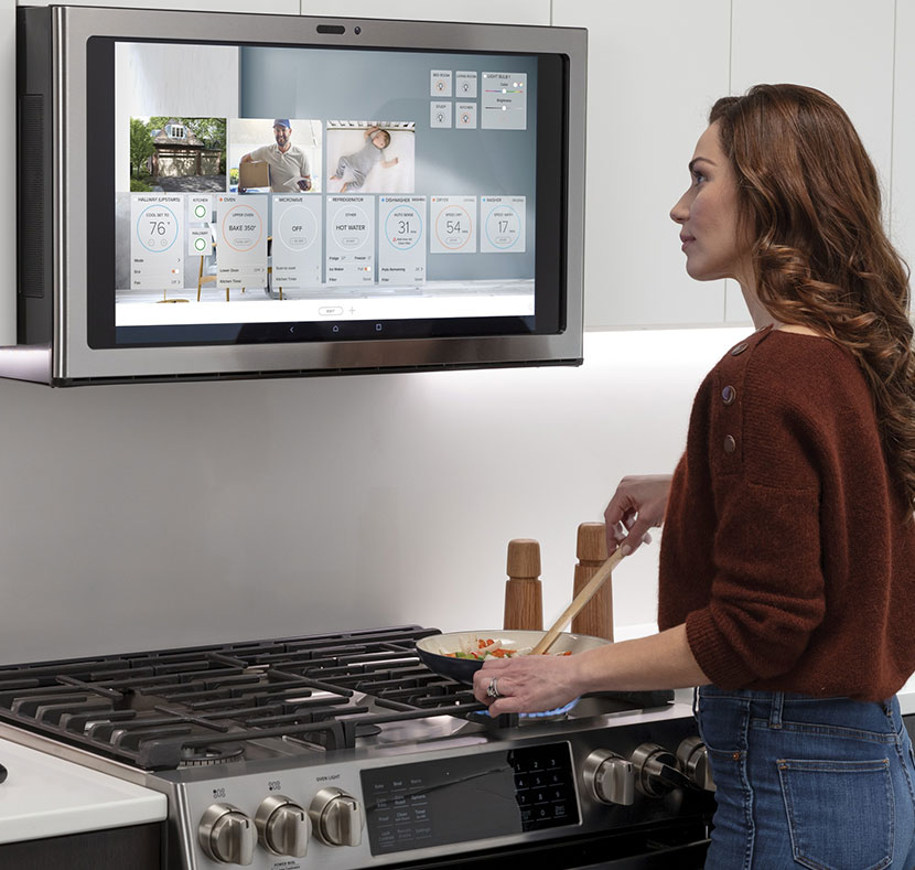 Woman looking at GE Profile Kitchen Hub recipe directions while cooking.